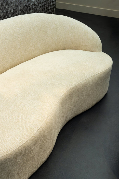 Moderne beige bank in organische vorm met zachte polyester bekleding.