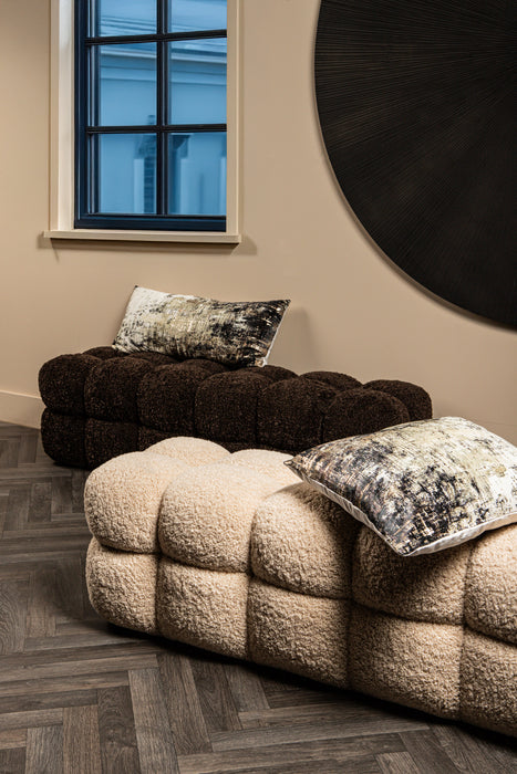 Beige en donkerbruine teddy bankjes met een zachte bouclé textuur en decoratieve kussens in een modern interieur.