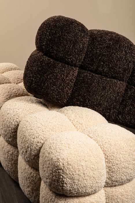 Beige en donkerbruin teddy bankje met een zachte bouclé textuur en een gestoffeerd, modulair ontwerp.