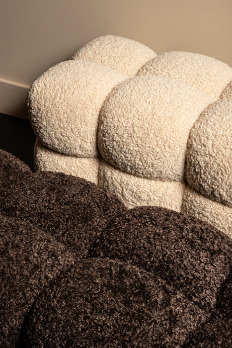 Bruin en beige teddy bankje met zachte bouclé textuur en een speels, gewelfd design voor een warm interieur.