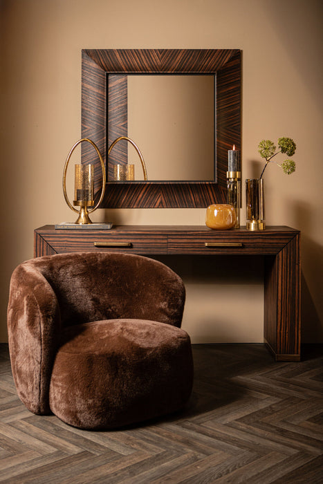 Bruine PTMD Tiess bijzettafel van houtfineer (45x165 cm) met een stijlvol gestreept houtnerfpatroon in een sfeervol interieur.