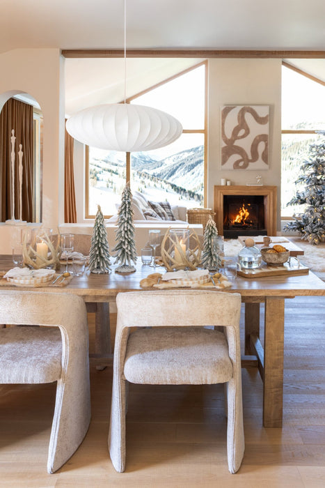 Beige gestoffeerde eetkamerstoel met een modern ontwerp in een sfeervol ingerichte woonkamer.