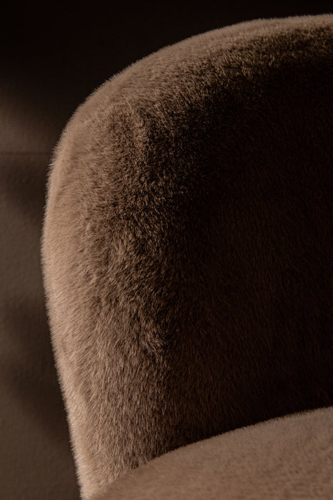 Close-up van een mocca-kleurige fauteuil met zachte, bontachtige polyester bekleding van PTMD.