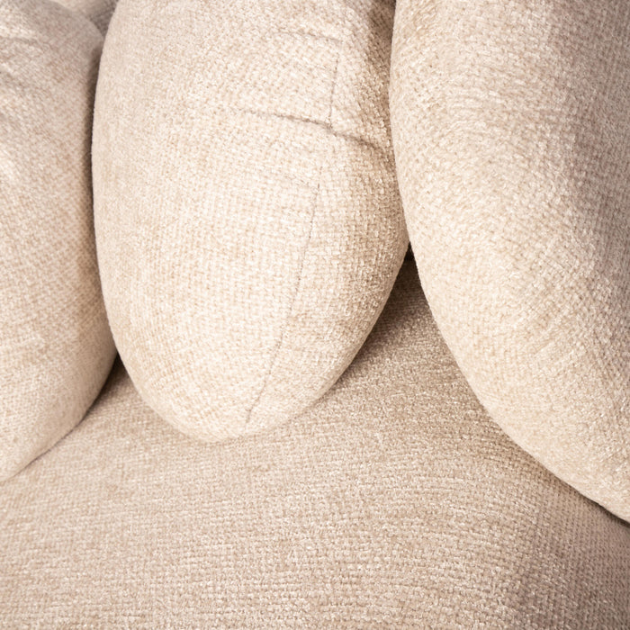 Close-up van crèmekleurige fauteuil Aphrodite van PTMD met zachte, geweven polyester bekleding en ronde vormen.