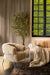 Luxe beige fauteuil van PTMD met zachte polyester bekleding en slank onderstel in een sfeervol interieur.