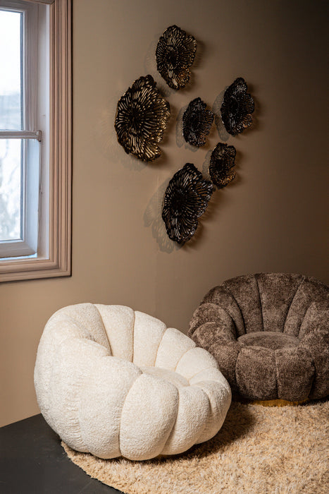 Crème polyester fauteuil Daisy met bloemvormige kuip en goudkleurig onderstel in een sfeervol interieur.