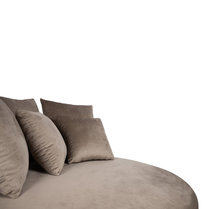 Ronde fauteuil Fayen van PTMD in zandkleurig fluweel met bijpassende sierkussens.