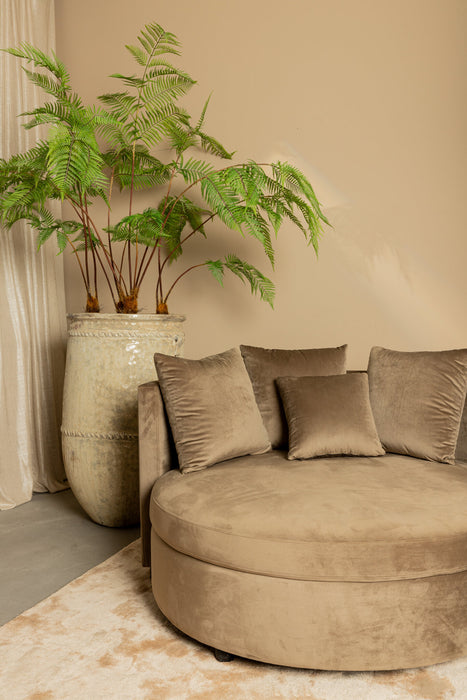 Ronde beige fauteuil van PTMD in zachte polyester fluweelstof met bijpassende sierkussens in een modern interieur.
