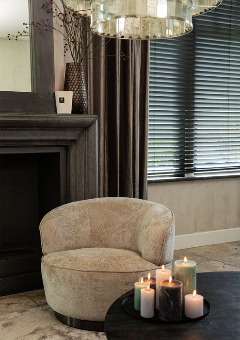 Beige polyester fauteuil Filou van PTMD met een slank metalen onderstel in een sfeervol interieur.