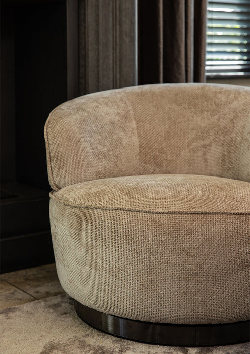 Beige fauteuil Filou van PTMD met gestructureerde polyester bekleding en een slank metalen onderstel.