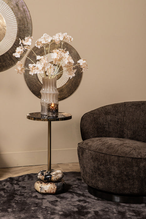 Bruine polyester fauteuil Filou van PTMD met een slank metalen onderstel in een sfeervol ingerichte woonkamer.