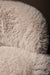 Close-up van beige Franklyn fauteuil met zachte, aaibare polyester bekleding in een harige textuur.