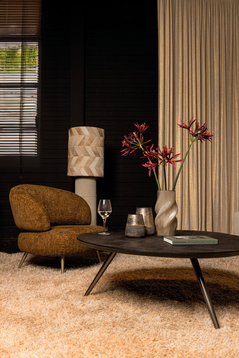 Groene polyester fauteuil Franklyn van PTMD met slank metalen onderstel in een sfeervol interieur.