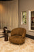 Moderne amberkleurige fauteuil met gestructureerde polyester bekleding en slank metalen onderstel.