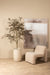 Beige polyester fauteuil Oslo van PTMD met een moderne, organische vormgeving in een sfeervol interieur.