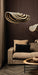 PTMD Loulou hanglamp van rotan met golvend design in naturel en zwart, hangend boven een bank in een sfeervol interieur.