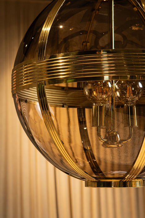Ronde PTMD hanglamp van goudkleurig messing en glas, 66x66x91 cm, met een luxe bolvormig design en zichtbare lichtbronnen.