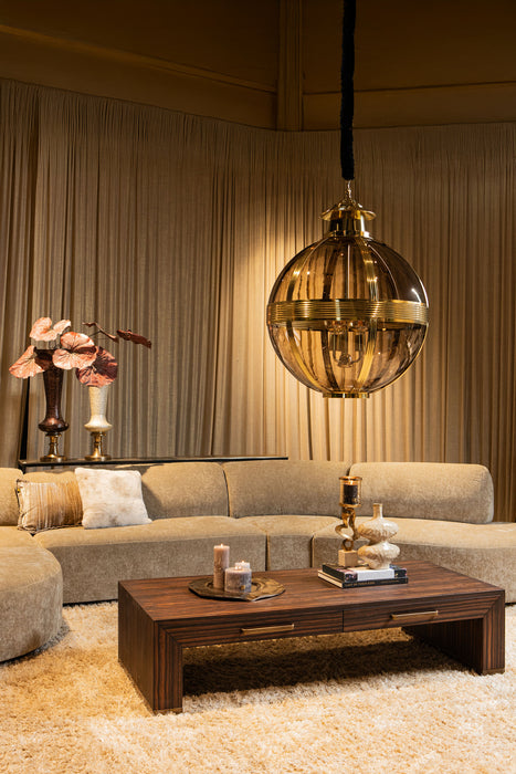 Grote ronde PTMD hanglamp van glas met messingkleurige details in een sfeervol interieur.