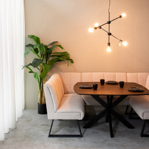 LABEL51 Modula 2-zits eetkamerbank in naturel bouclé met zwart metalen frame aan een houten eettafel.