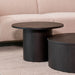 Ronde zwarte salontafel Oliva van eikenhout met een cilindervormig onderstel voor een modern interieur.