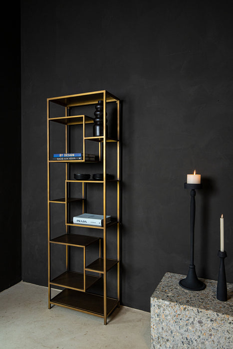 Gouden ijzeren vakkenkast van 30x60x195 cm met asymmetrische planken tegen een donkere muur.