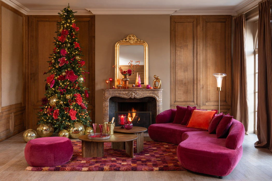 Transparante glazen vloerlamp van 155 cm hoog in een sfeervol ingerichte woonkamer met kerstboom en roze bank.